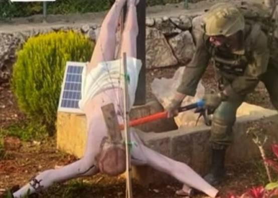 جندي إسرائيلي يحطم تمثالا للسيد المسيح