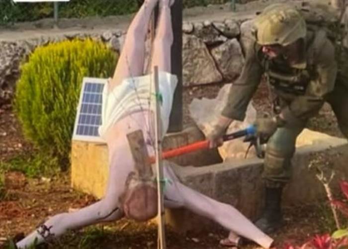 جندي إسرائيلي يحطم تمثالا للسيد المسيح